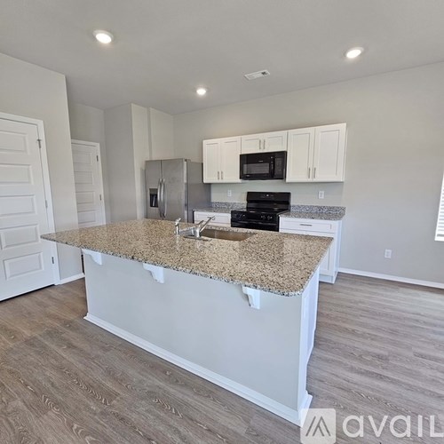 A kitchen with granite countertops and white cabinets.