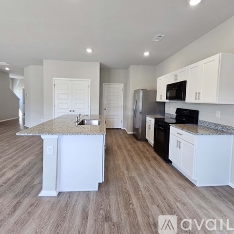 A kitchen with white cabinets and a granite countertop.