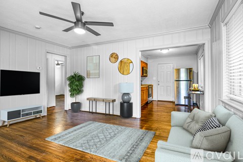 A living room with a grey couch and a wooden floor.