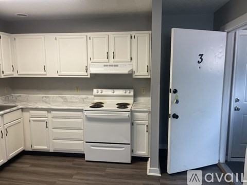A kitchen with white appliances and cabinets with a door marked 3.