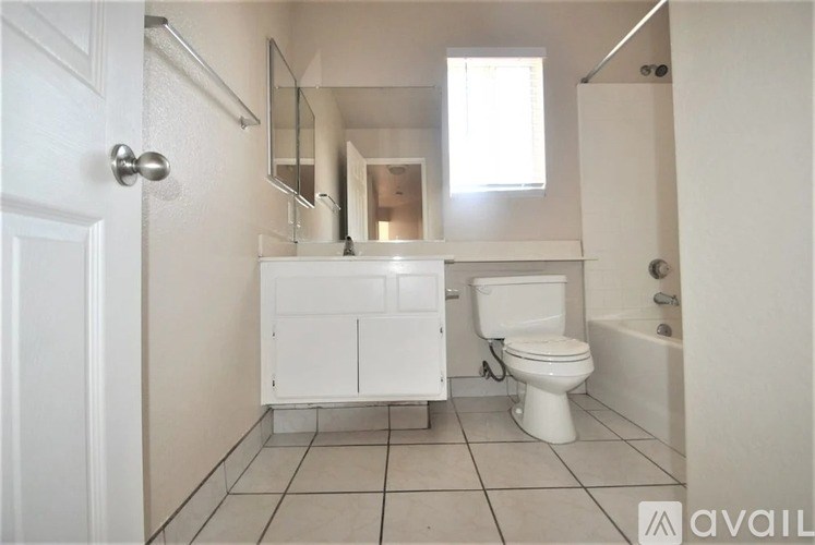 A white bathroom with a toilet, sink, and bathtub.