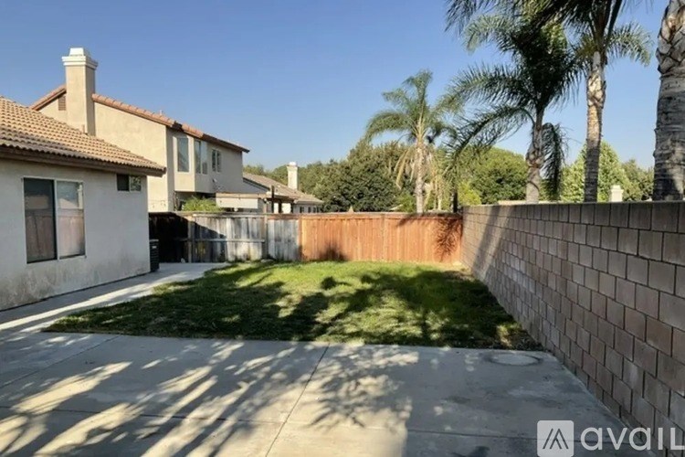 A sunny day in a residential area with houses and palm trees.