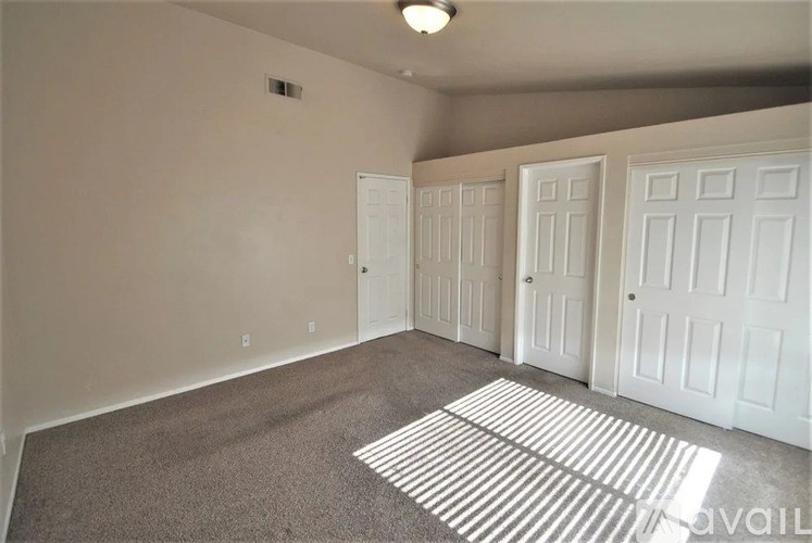 A room with white doors and a carpeted floor.