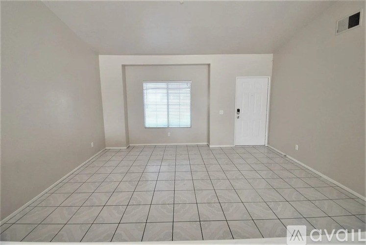 A room with a tiled floor and a window with blinds.
