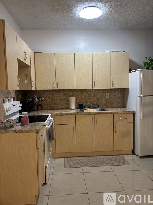 A kitchen with white cabinets and a wooden floor.