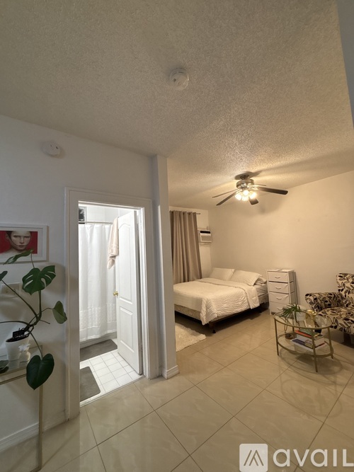 A bedroom with a bed, dresser, and ceiling fan.