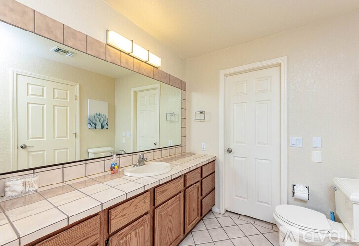 A bathroom with a sink, mirror, and toilet.