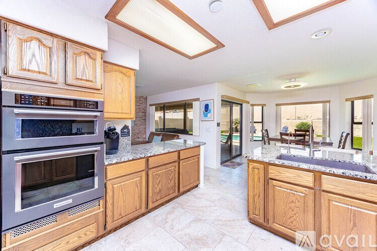 A modern kitchen with wooden cabinets and a stainless steel oven.