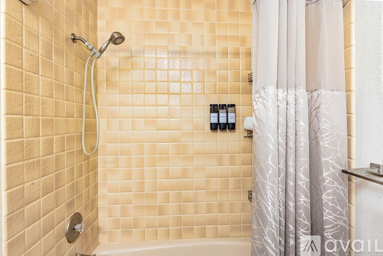 A shower area with a glass door and a shower head.