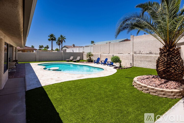A backyard with a pool and a palm tree.