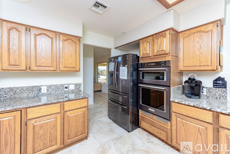 A kitchen with wooden cabinets and granite countertops.