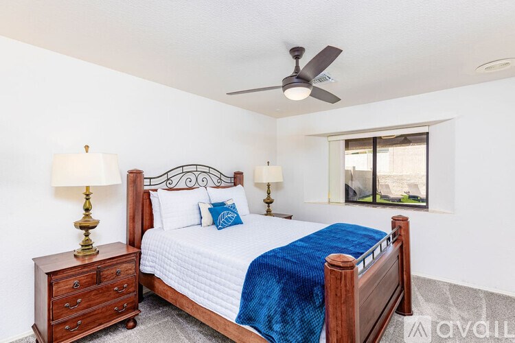 A bedroom with a bed, nightstand, and window.
