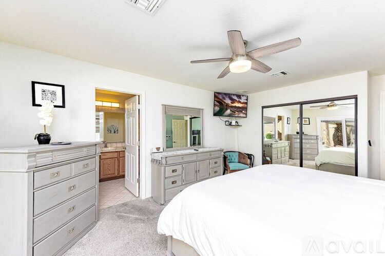A bedroom with a bed, dresser, and mirror.