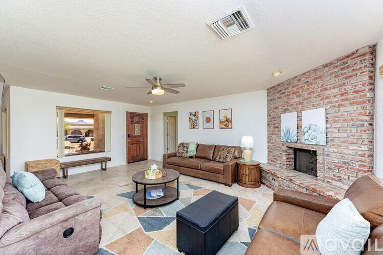 A living room with a brick wall and a fireplace.