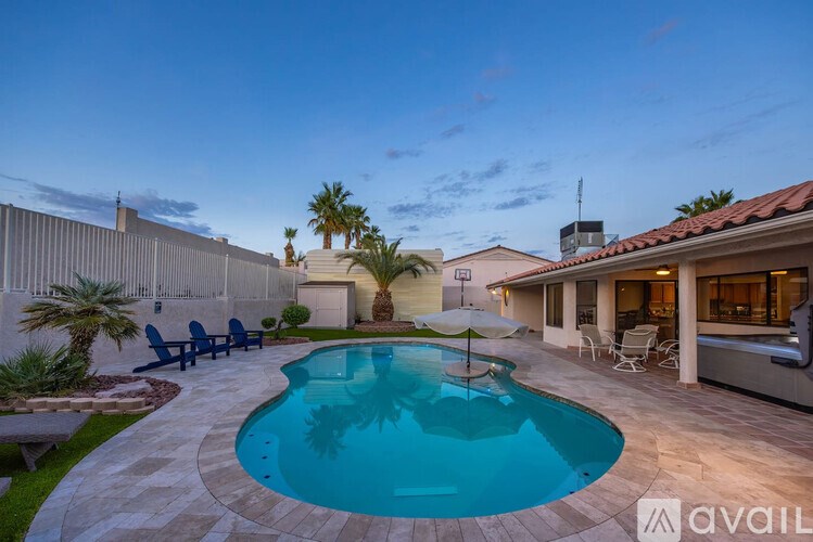 A pool surrounded by a patio and a house.