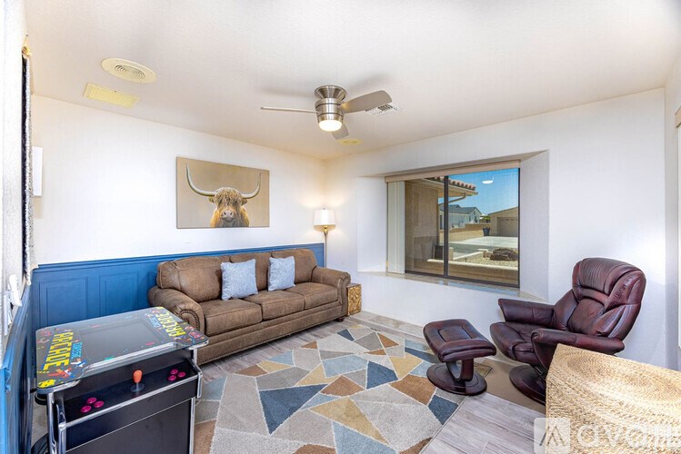 A living room with a couch, chair, and a fan.