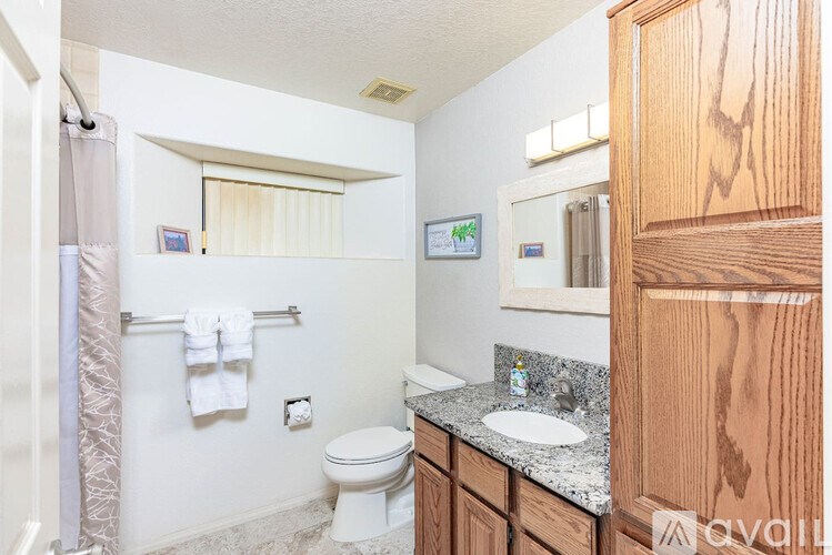 A bathroom with a toilet, sink, and mirror.