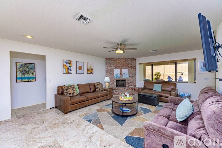 A living room with a brown couch and a fireplace.
