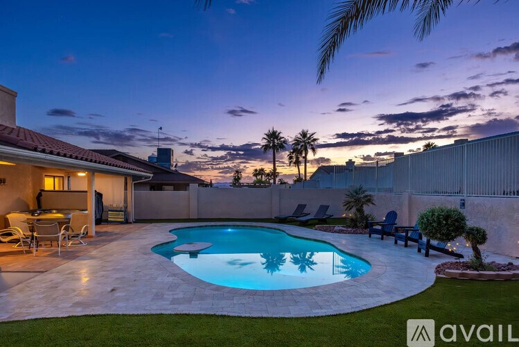 A backyard with a pool and patio furniture.