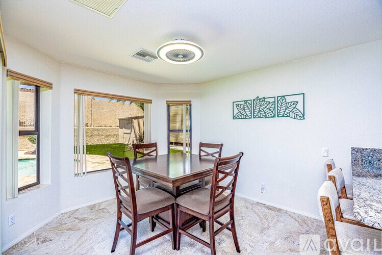 A dining room with a table and chairs.