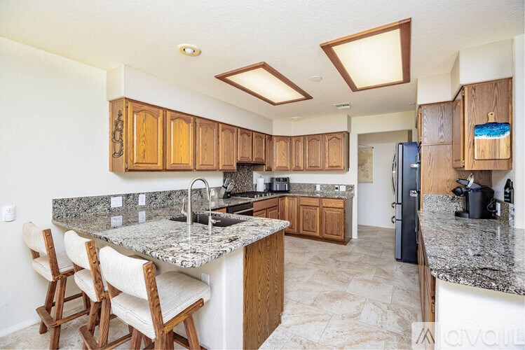 A kitchen with granite countertops and wooden cabinets.