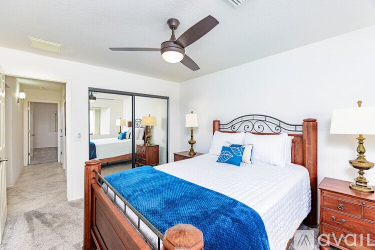 A bedroom with a bed, dresser, and mirror.