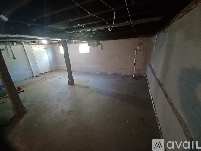 A spacious basement with concrete floors and exposed pipes.