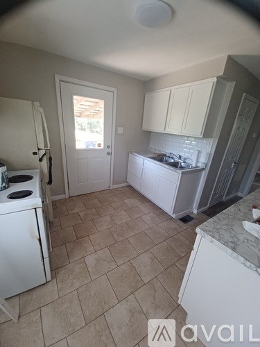 A kitchen with a white stove and cabinets.