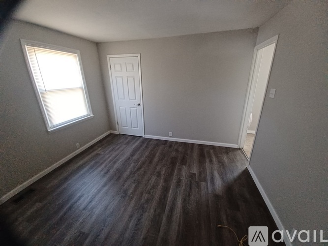 A room with a wooden floor and two doors.