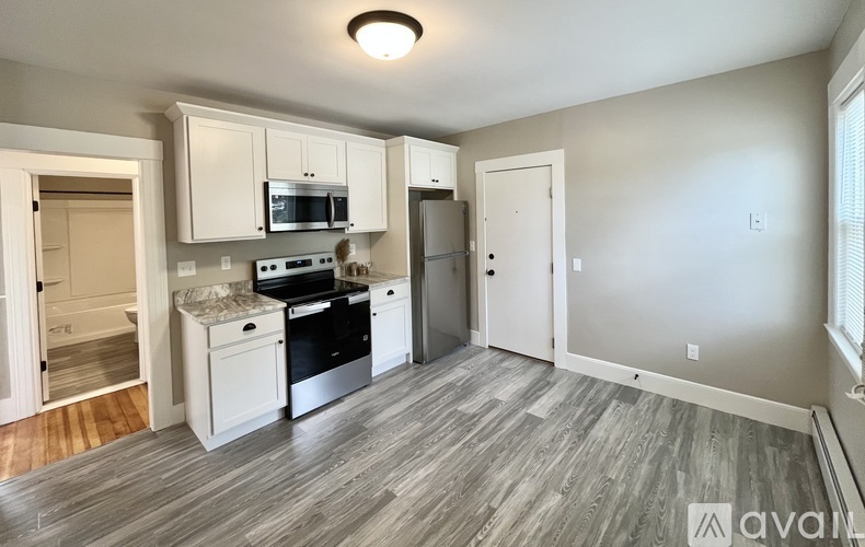 A kitchen with white cabinets and a microwave above the stove.