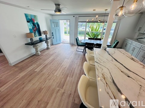 A living room with a marble table and wooden floors.