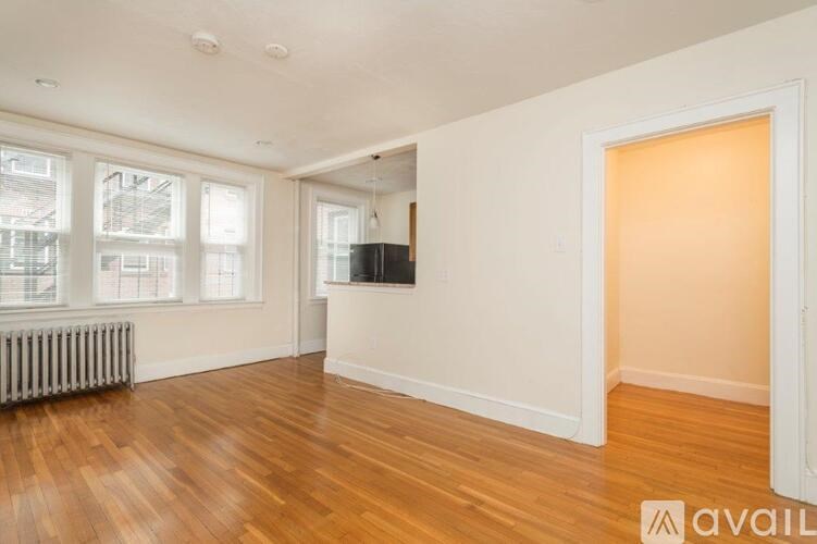 A room with wooden floors and a television mounted on the wall.
