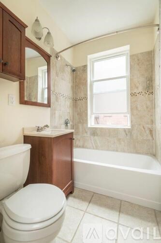 A white toilet sits next to a bathtub in a bathroom.