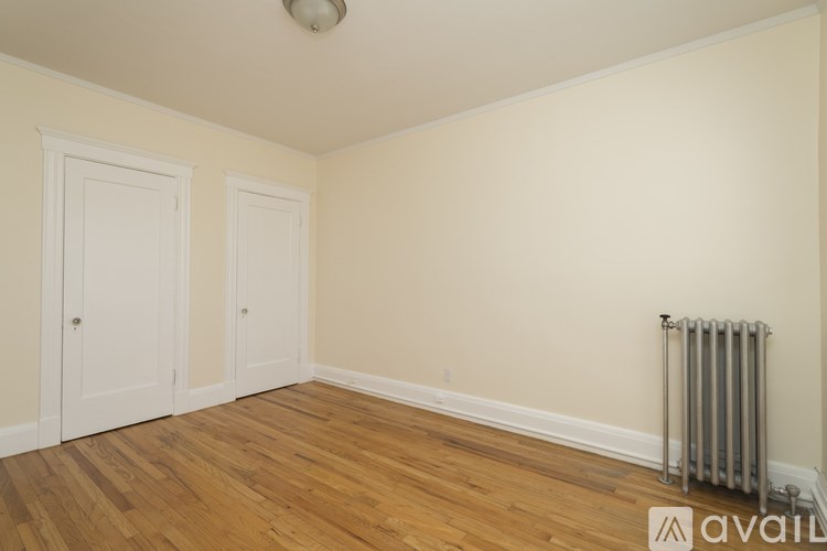 A room with wooden floors and a radiator on the wall.