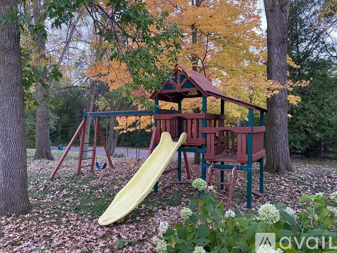 A playground with a yellow slide and a red and green structure.