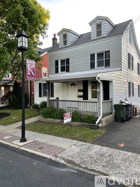 A house with a "For Sale" sign in front of it.