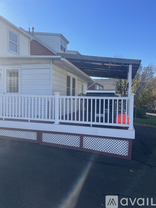 A white house with a red ball on the porch.