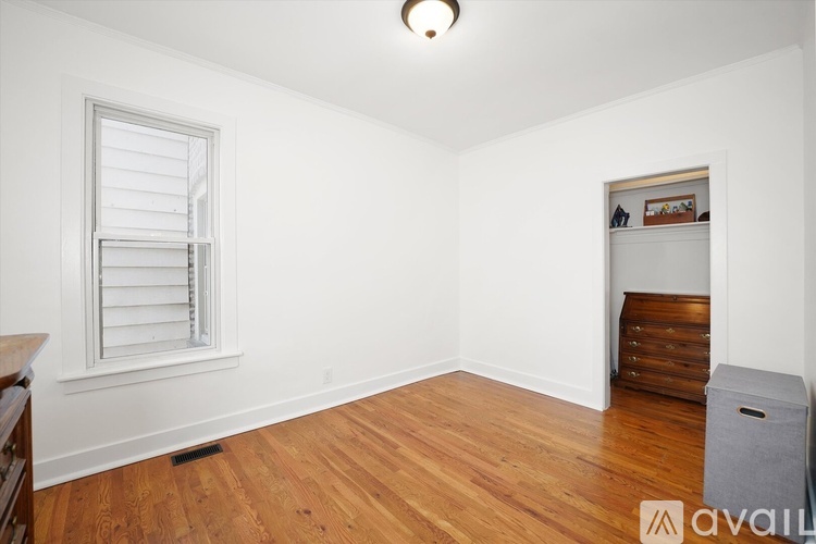 A bedroom with a bed, a ceiling fan, and a wardrobe.