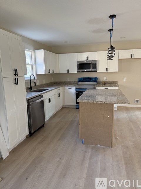 A kitchen with a dishwasher, sink, and a countertop.