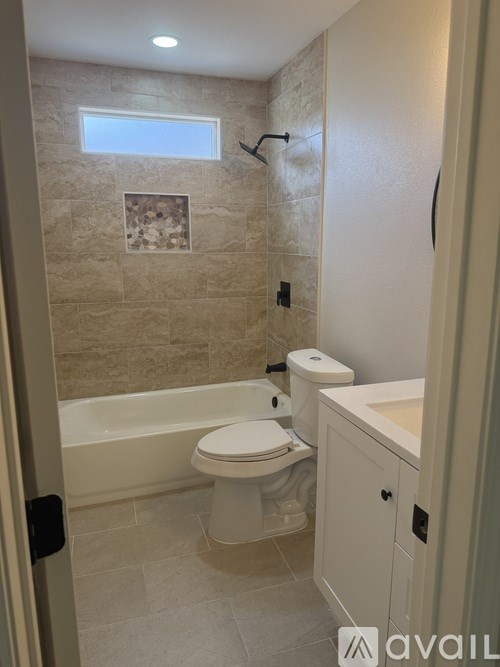 A bathroom with a toilet, sink, and tub.