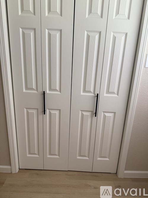 A pair of white doors with black handles.
