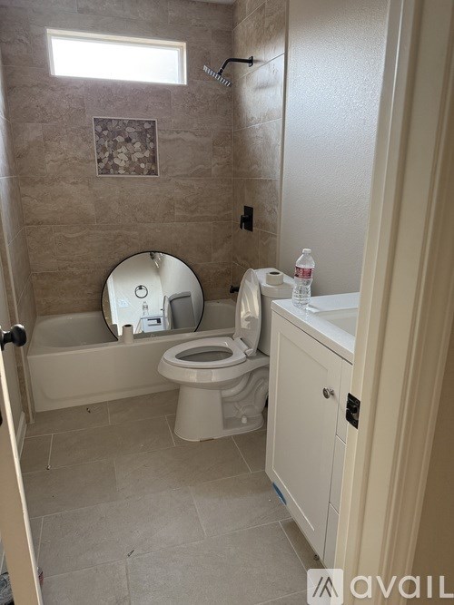 A bathroom with a toilet, sink, and a window.