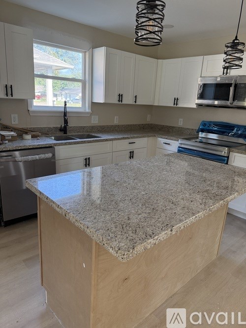 A kitchen with granite countertops and wooden cabinets.