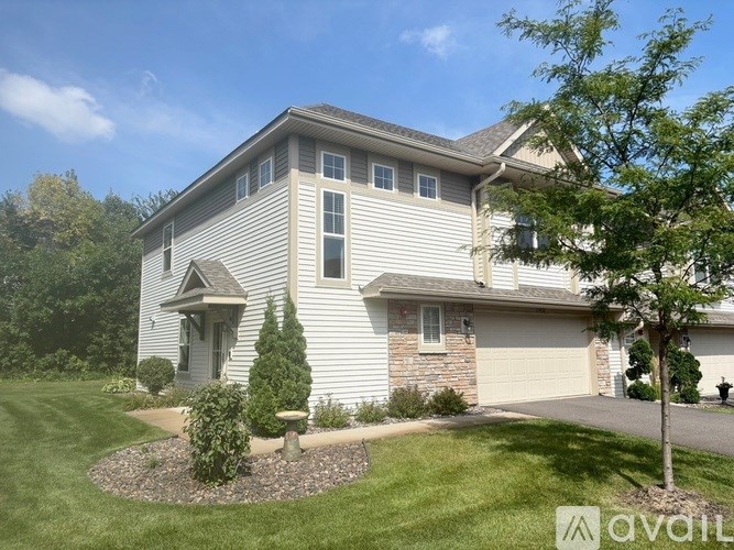 A house with a grey siding and a white garage door.