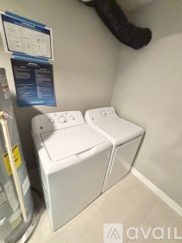 Two white washing machines in a small room.