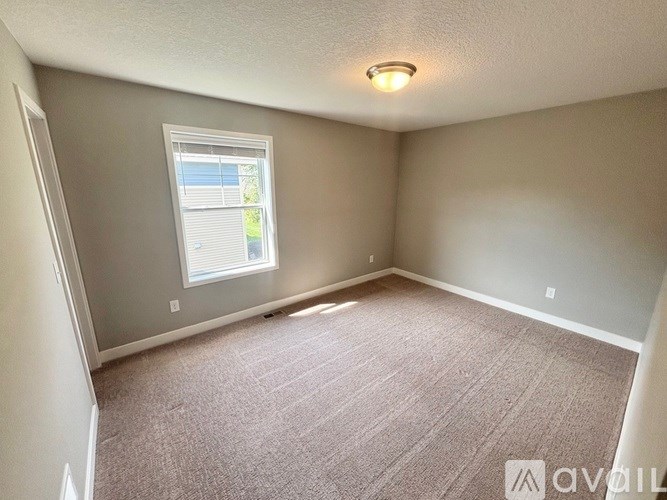 A room with a carpeted floor and a window.