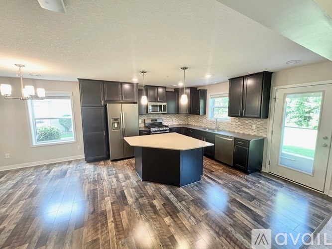 A kitchen with a wooden floor and a white ceiling.