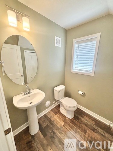 A bathroom with a sink, toilet and mirror.