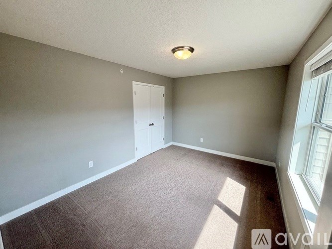 A room with a carpeted floor and a door.