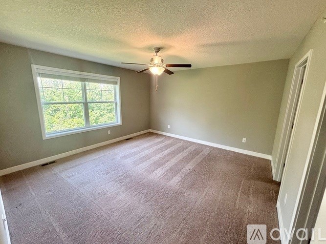 Empty room with carpeted floor and a window.